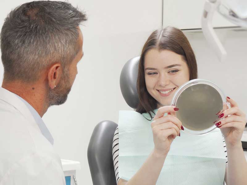 Happy Patient Looking at Her Face by Mirror