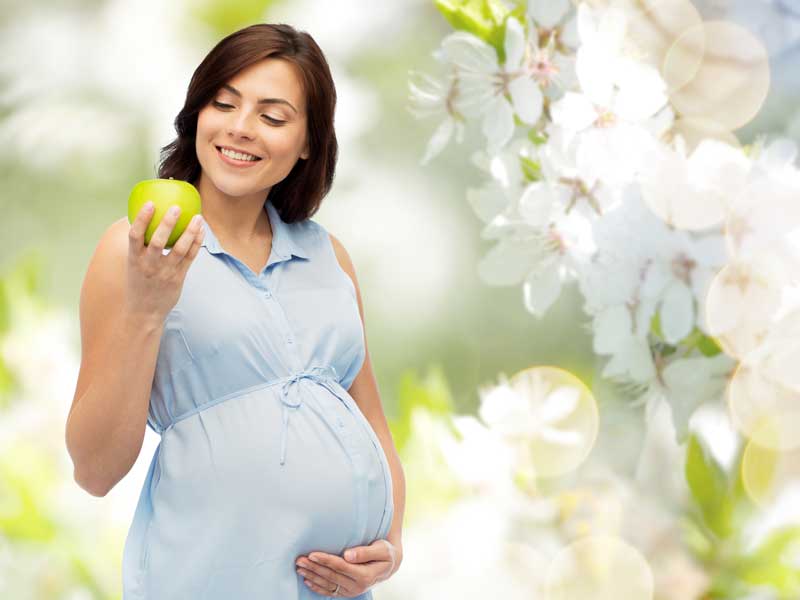 Pregnant Woman is Eating Apple